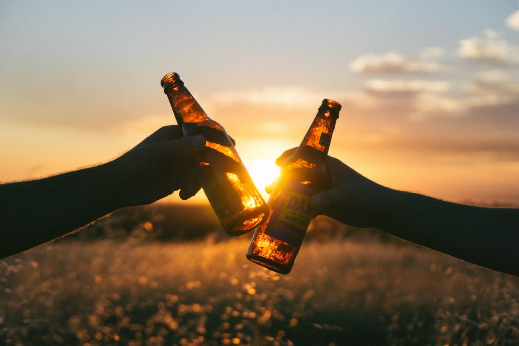 Musculation alcool week-end, quel est son impact sur tes résultats ? 1 photography of person holding glass bottles during sunset