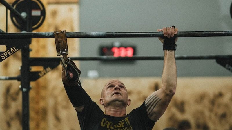 Le Crossfit, qu’est-ce que c’est ? 8 man in black crew neck t-shirt and gray shorts holding black metal bar