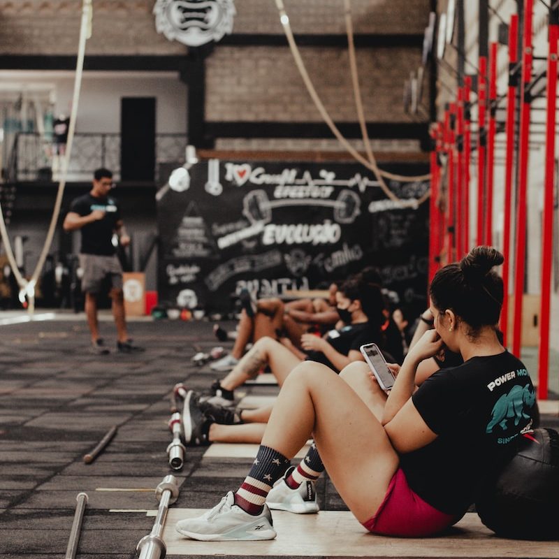 a group of people sitting on the ground in a gym