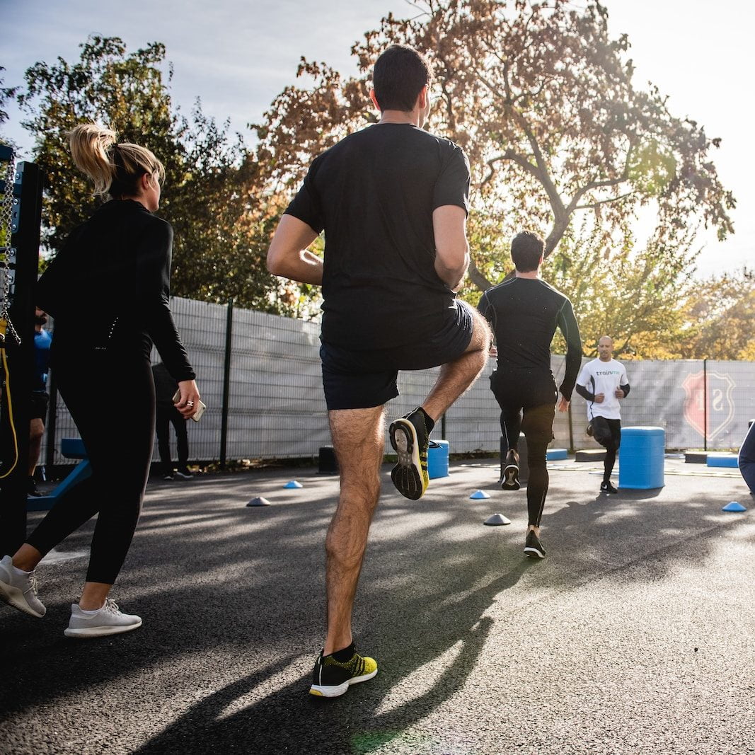 Le Crossfit, qu’est-ce que c’est ? 2 man in black t-shirt and black shorts running on road during daytime