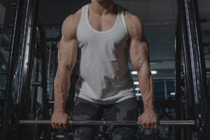 Man in White Tank Top Lifting Weights