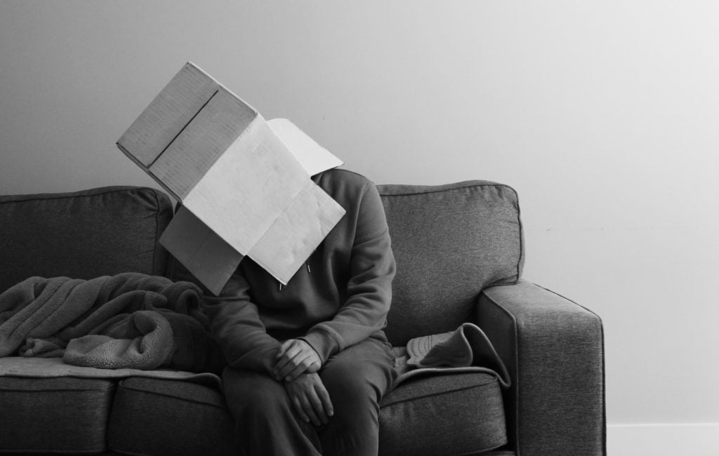 a person sitting on a couch with a book on their head