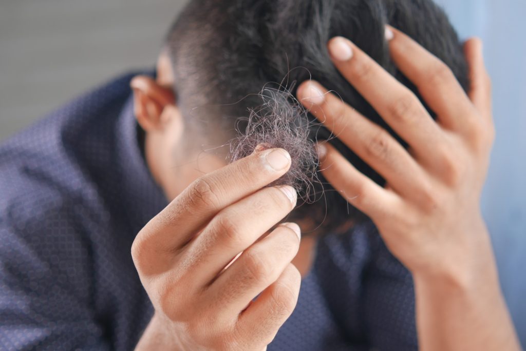 Creatine effets secondaire et dangers : la vérité 8 a man is combing his hair with his hands