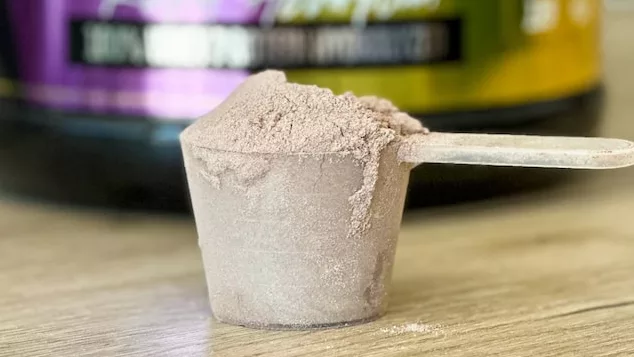 a jar of hydro protein and a spoon on a table