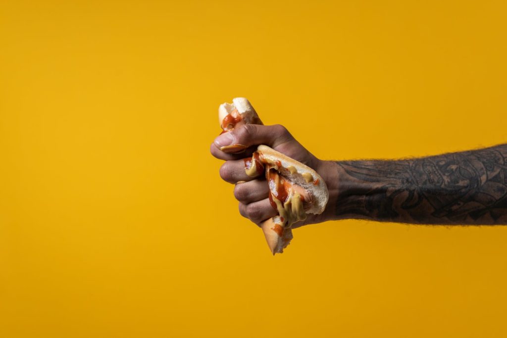 Person Squashing Hotdog